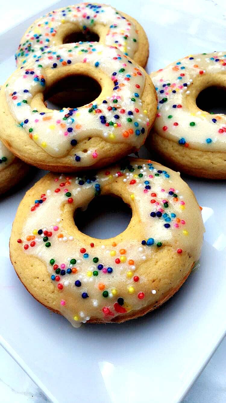 vanilla protein donuts with sprinkles on a white plate