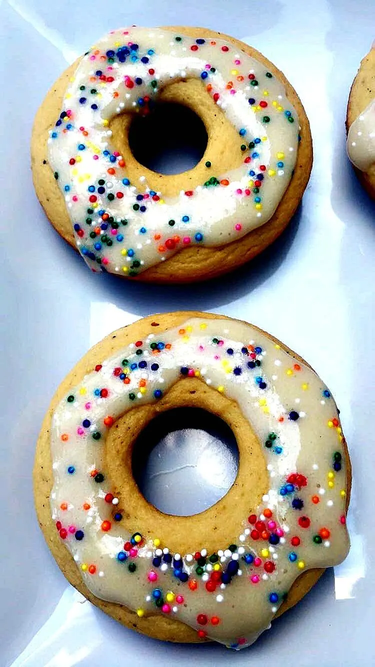 2 vanilla protein donuts with sprinkles on a white plate