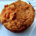 close up of two baked sweet potato protein muffin on a white plate