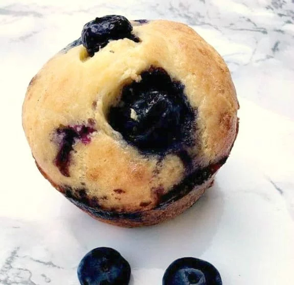 lemon blueberry protein muffin and 2 blueberries