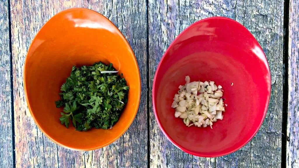 parsley and garlic in red and orange bowls