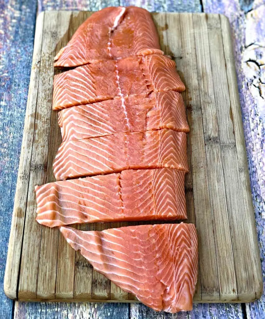 raw salmon sliced on a cutting board