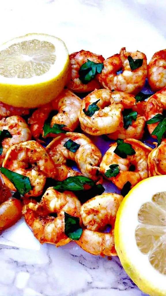 spicy smoky shrimp on a white surface with a lemon