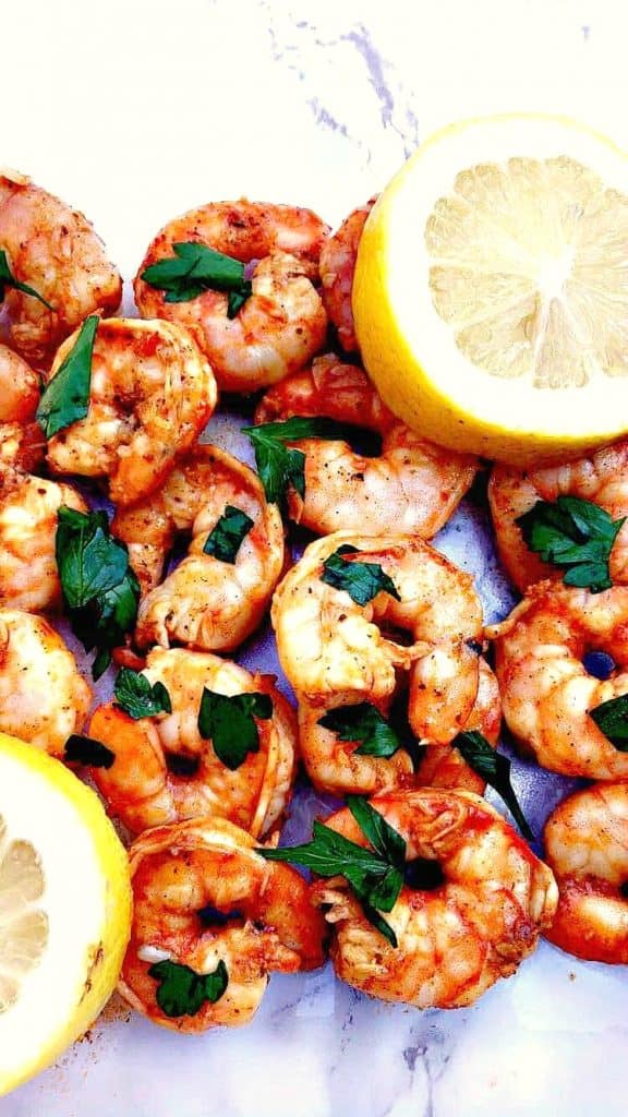 spicy smoky shrimp on a white surface with a lemon