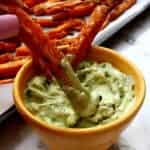 bowl of avocado garlic aioli with sweet potato fries