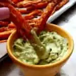 bowl of avocado garlic aioli with sweet potato fries