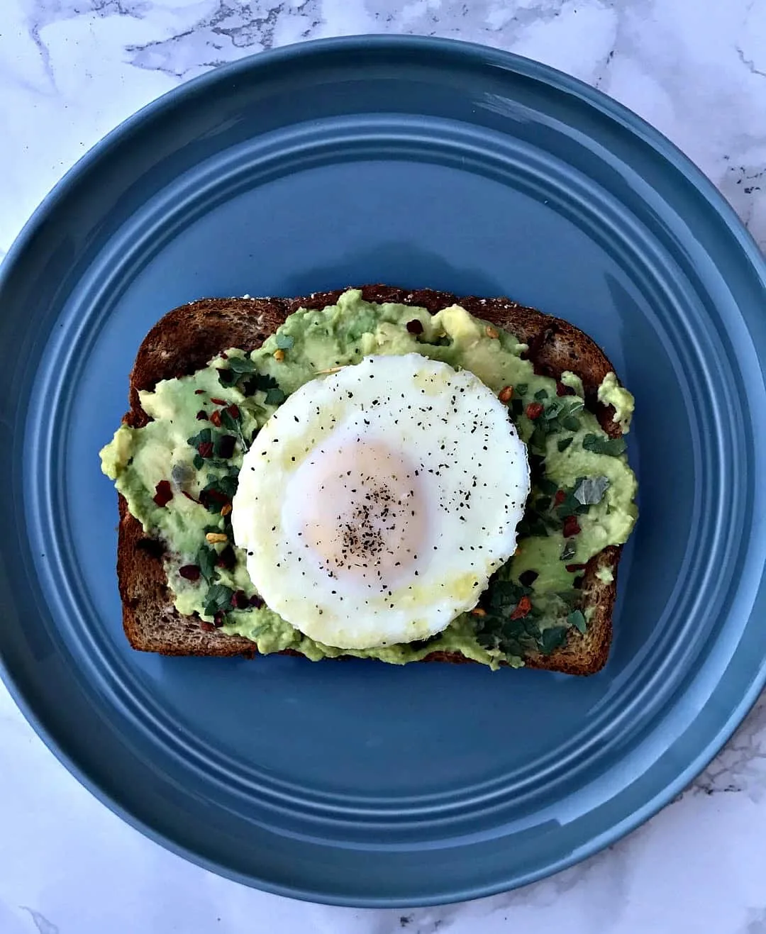 avocado cilantro lime toast with poached egg on a plate