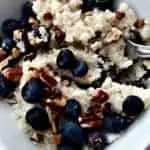 blueberry quinoa breakfast bowl with pecans in a white bowl