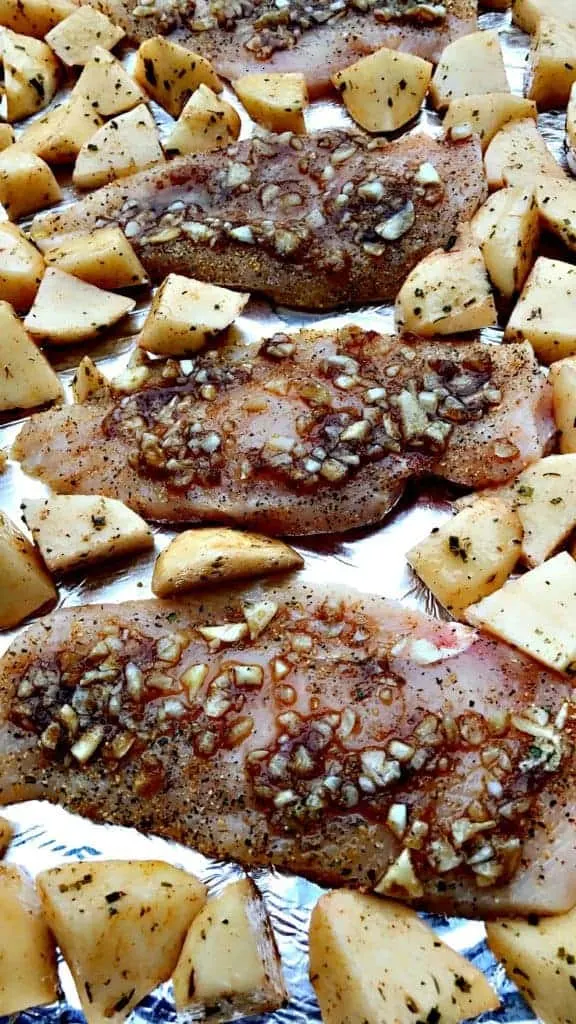 garlic brown sugar chicken and roasted potatoes on a foil lined baking sheet - precooked