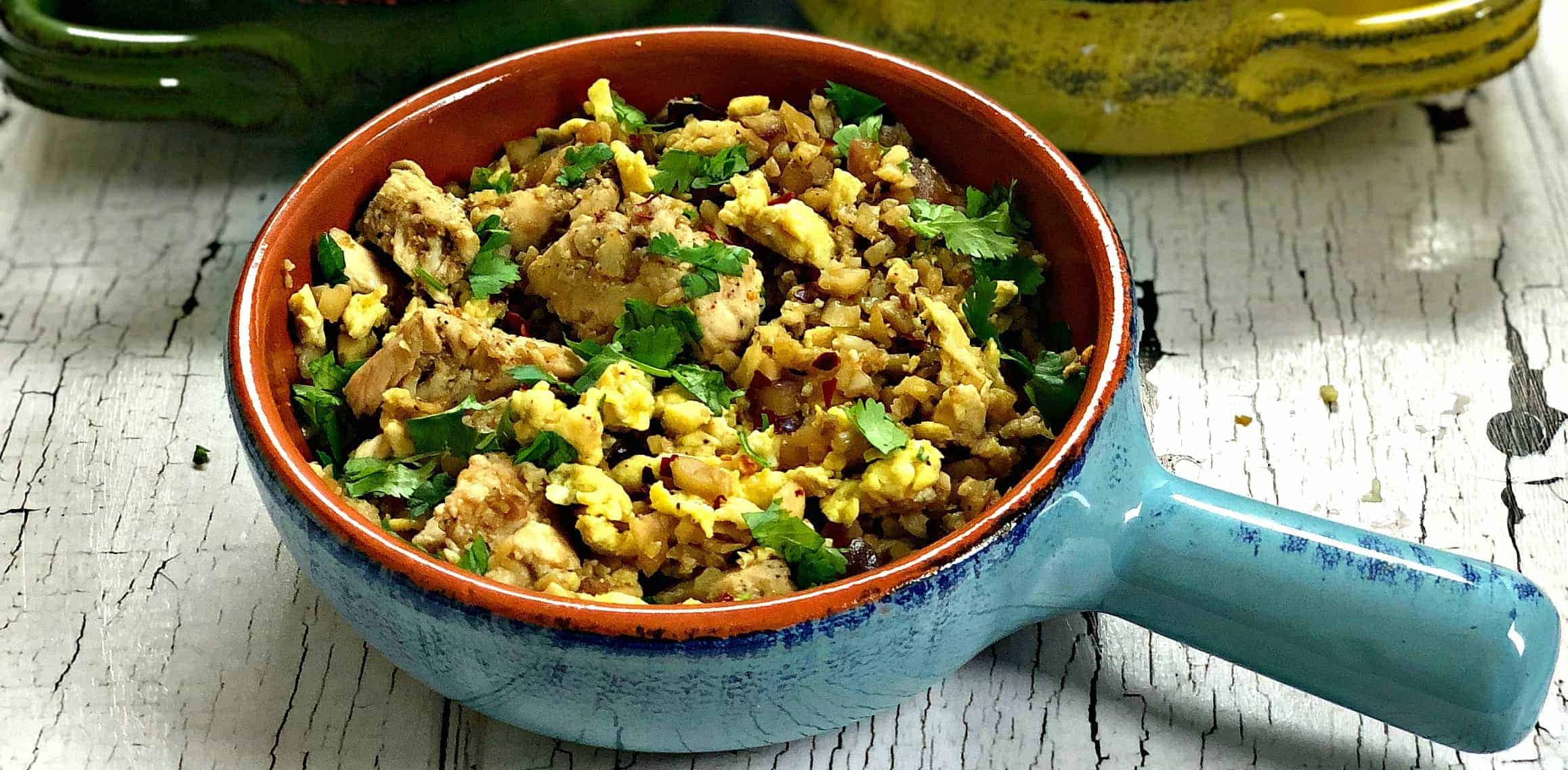 Low-Carb Paleo Cauliflower Vegetable Fried Rice with Chicken in a serving dish