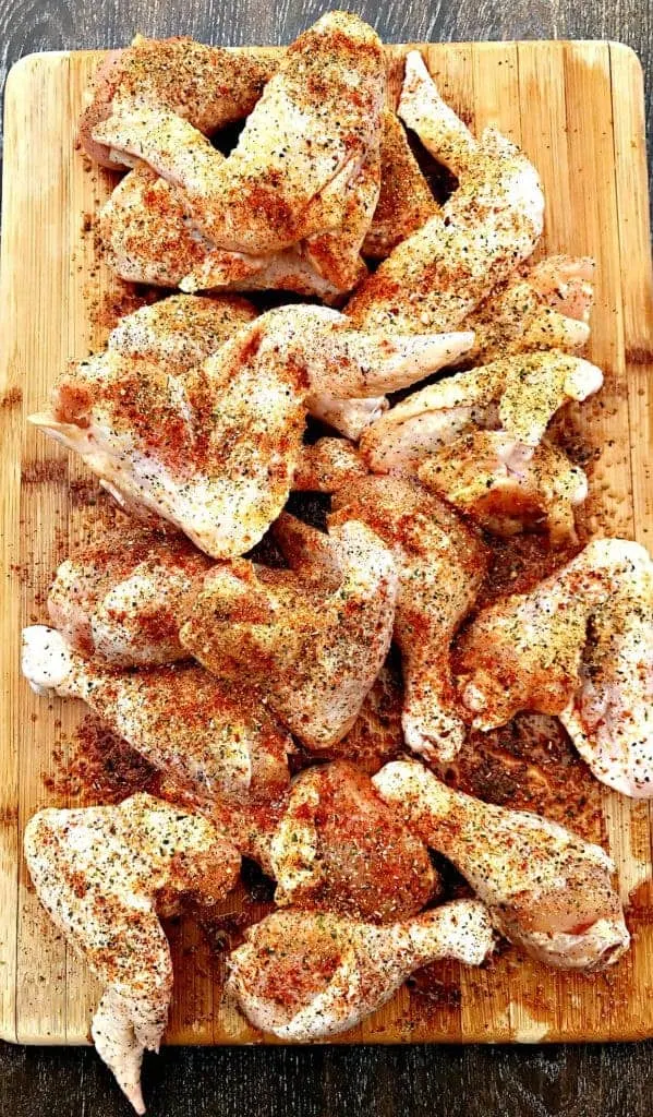 raw seasoned chicken breasts on a cutting board