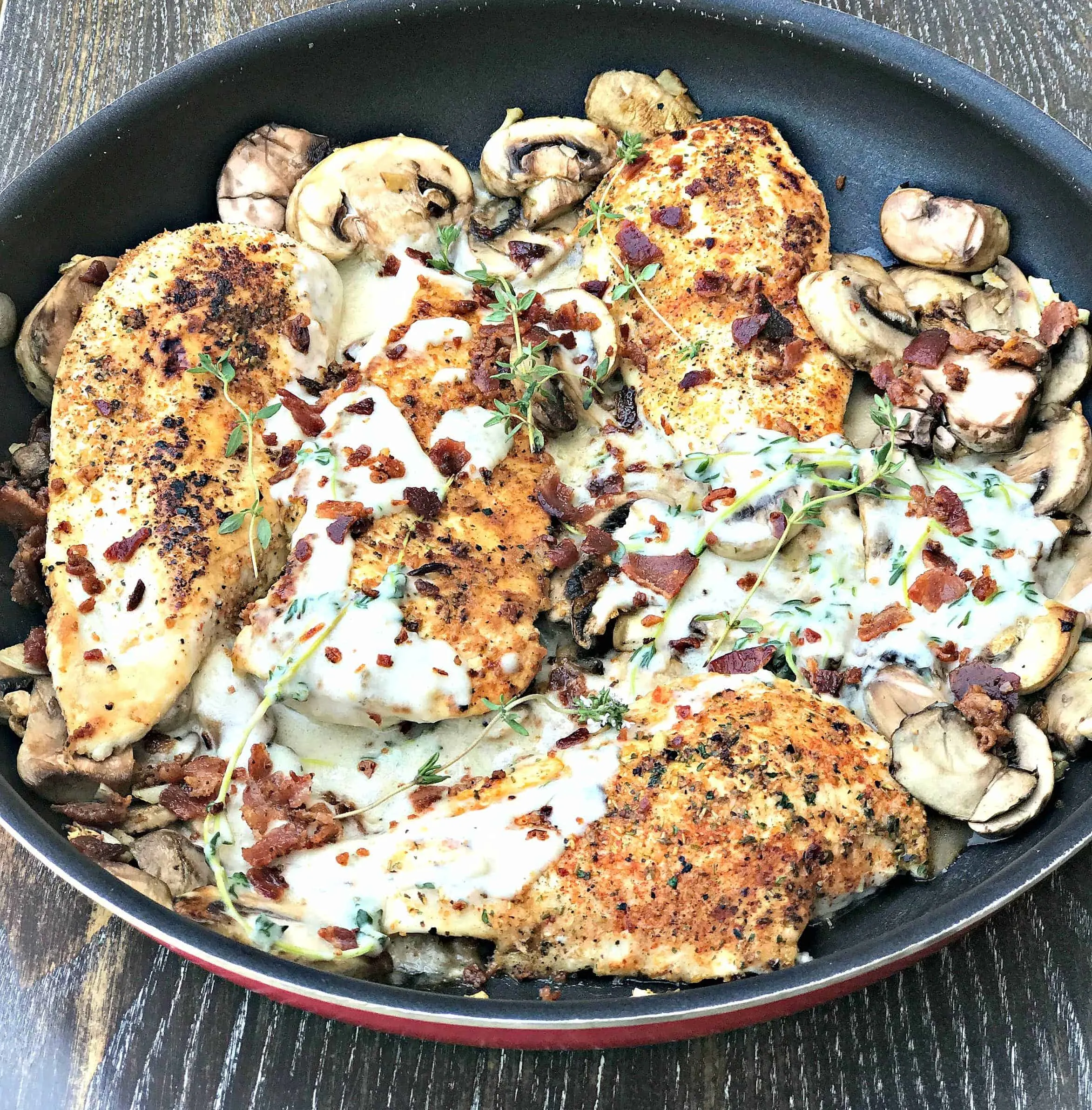 bacon mushroom chicken in cream sauce with thyme in a skillet