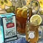 glass pitcher filled with sweet tea lemon bourbon cocktail, package of sweet tea tea bags, mason jar with sweet tea lemon bourbon cocktail with a slice of lemon