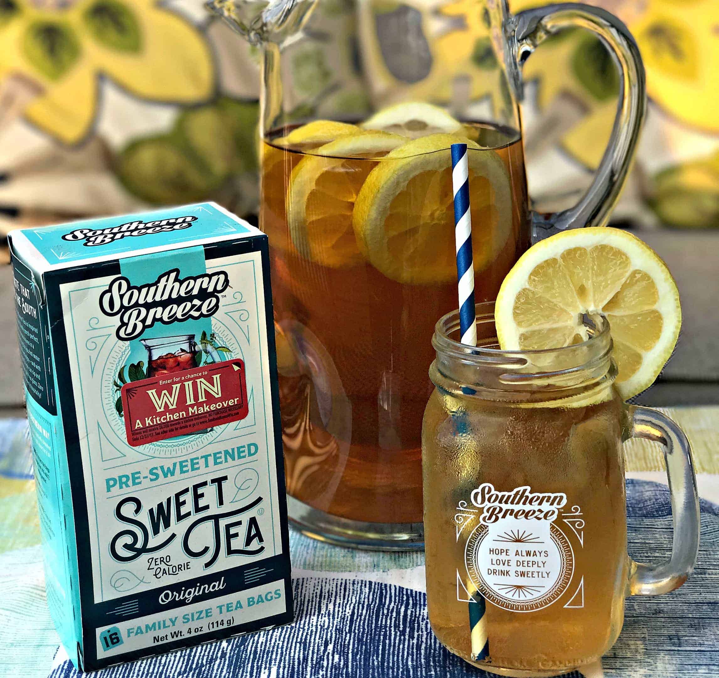 glass pitcher filled with sweet tea lemon bourbon cocktail, package of sweet tea tea bags, mason jar with sweet tea lemon bourbon cocktail with a slice of lemon