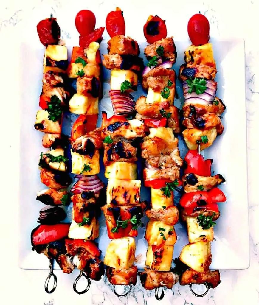 hawaiin pineapple chicken kabob skewers on a white plate