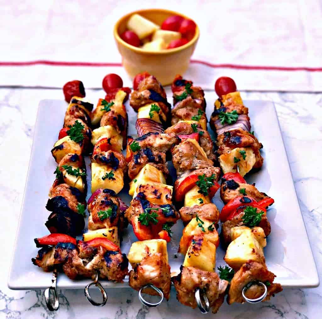 hawaiin pineapple chicken kabob skewers on a white plate