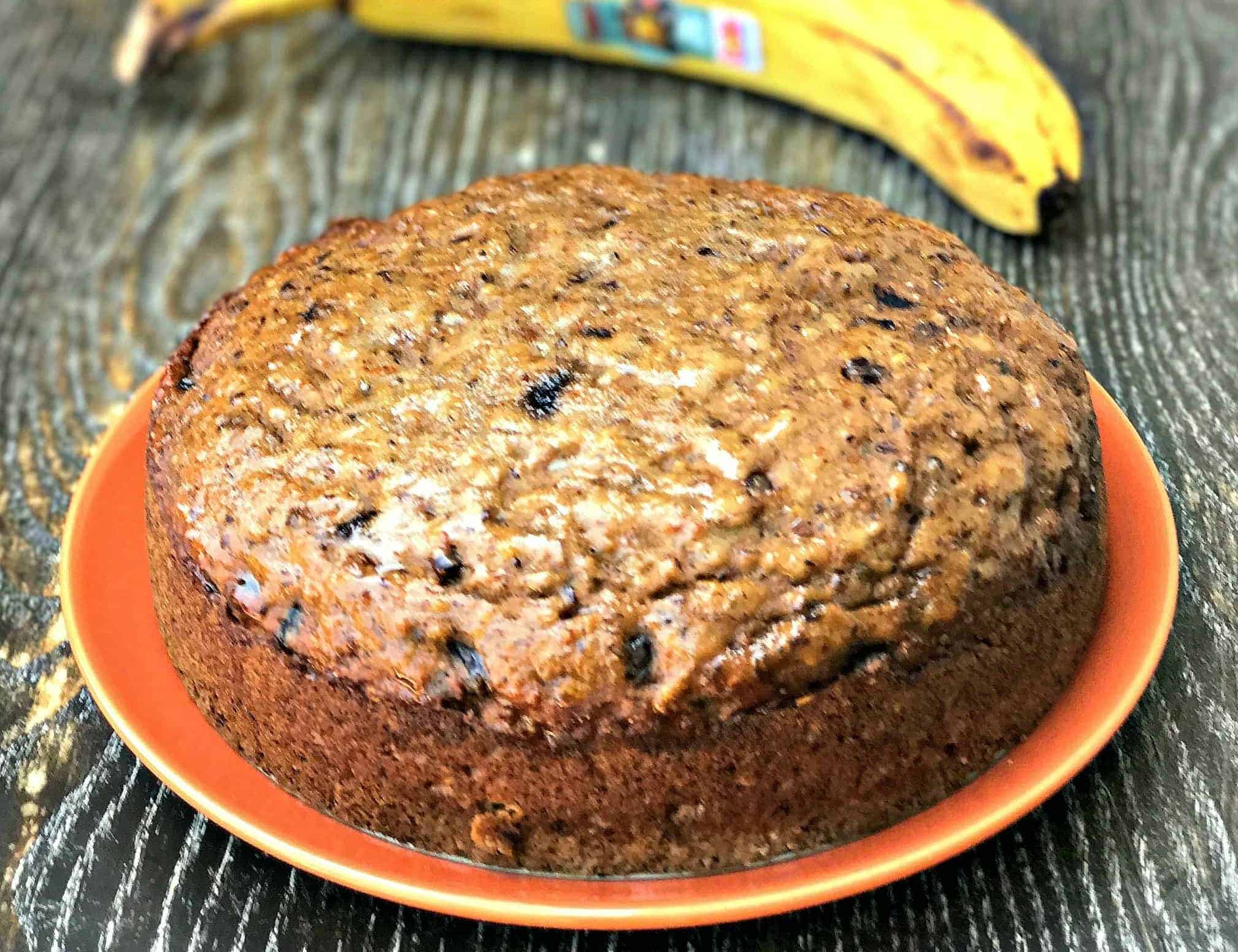 instant pot low carb banana nut bread on an orange plate next to a banana