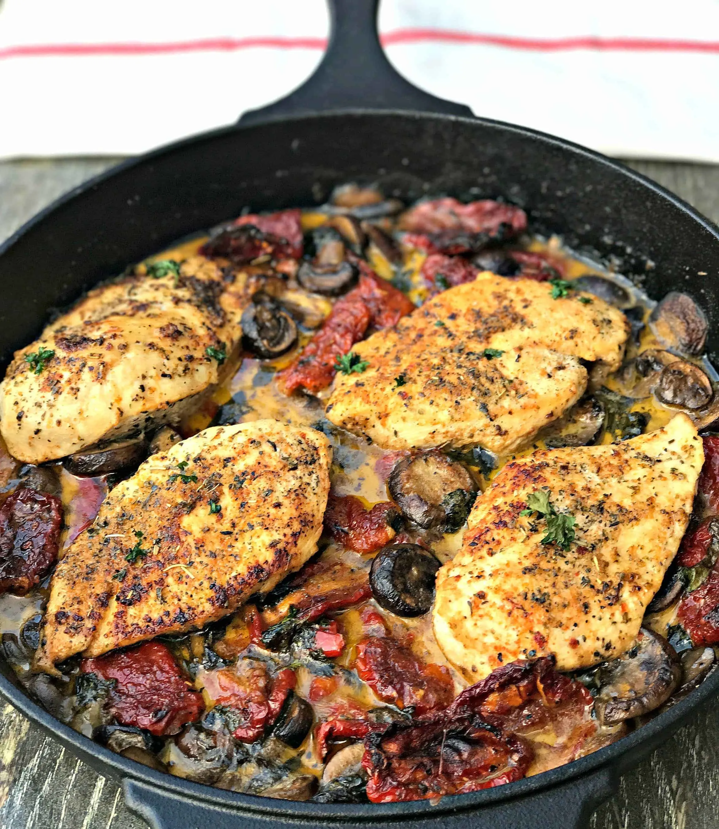Chicken with Sun-Dried Tomatoes and Mushrooms in White Wine Cream Sauce in a skillet
