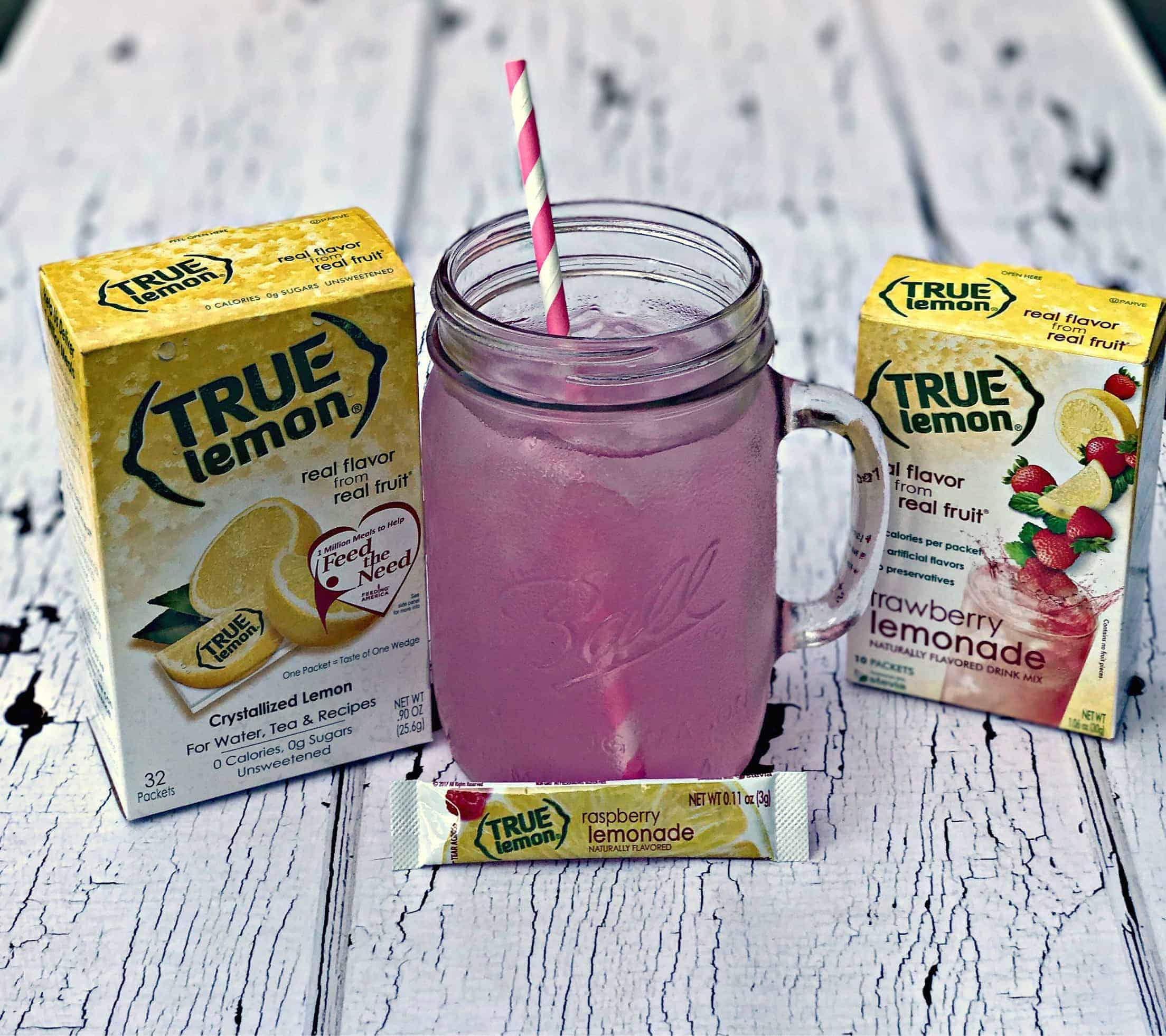 2 boxes of true lemon naturally flavored drink mix, a mason jar with raspberry lemonade and a pink and white straw