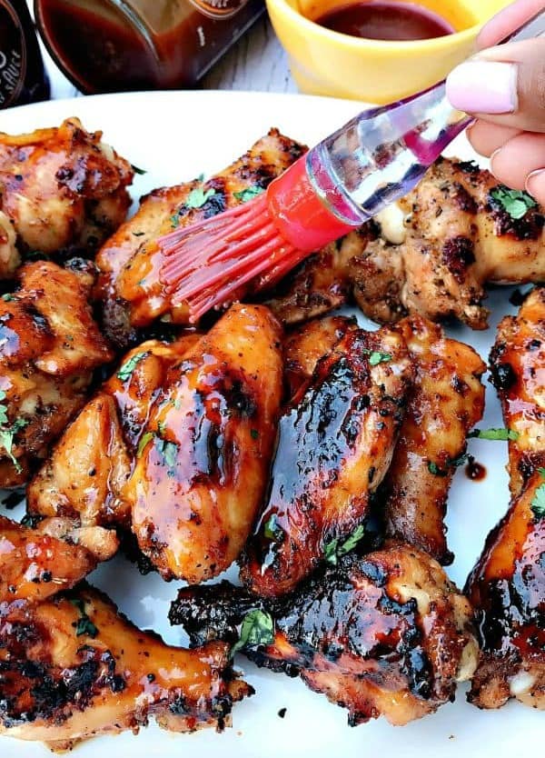 person placing bbq on ranch grilled chicken wings