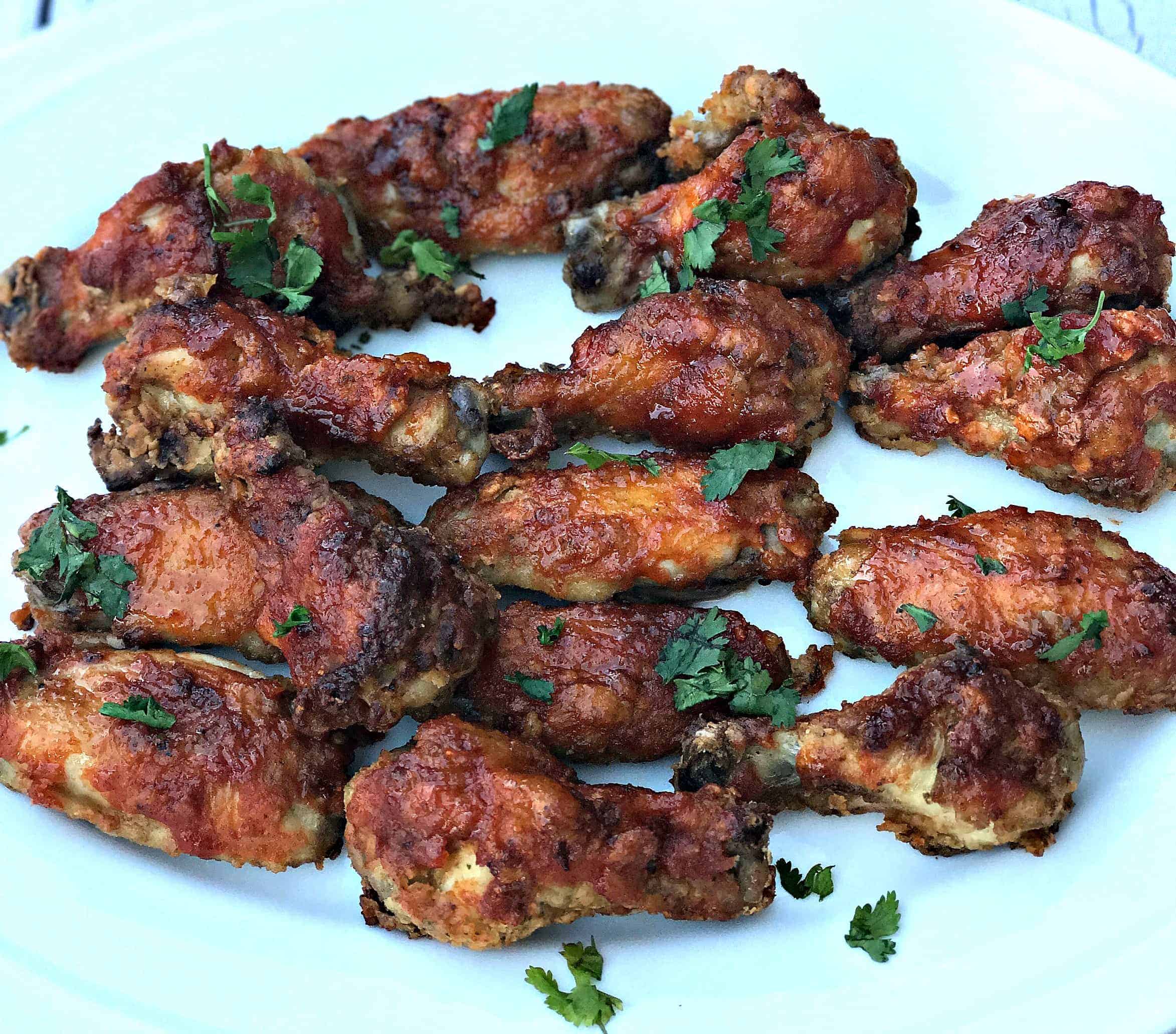 air fryer sriracha honey bourbon fried chicken wings on a white platter