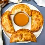 Air Fryer Apple Cinnamon Dessert Empanadas on a white plate with caramel