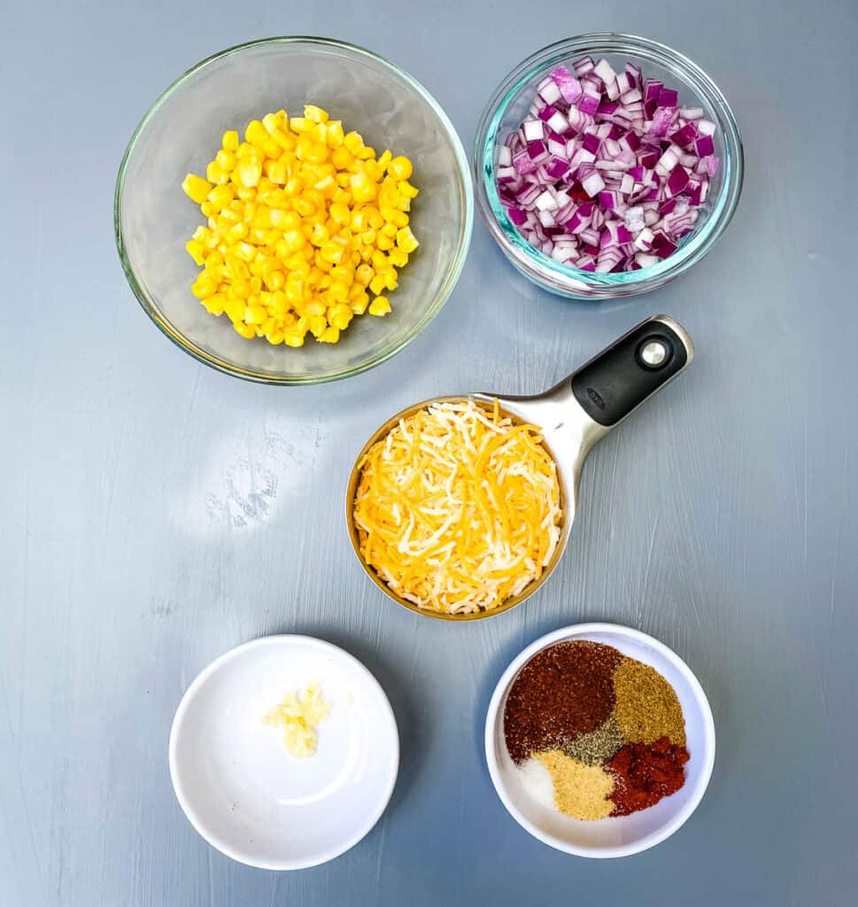 homemade taco seasoning, garlic, shredded Mexican cheese, chopped onions and frozen corn in separate bowls