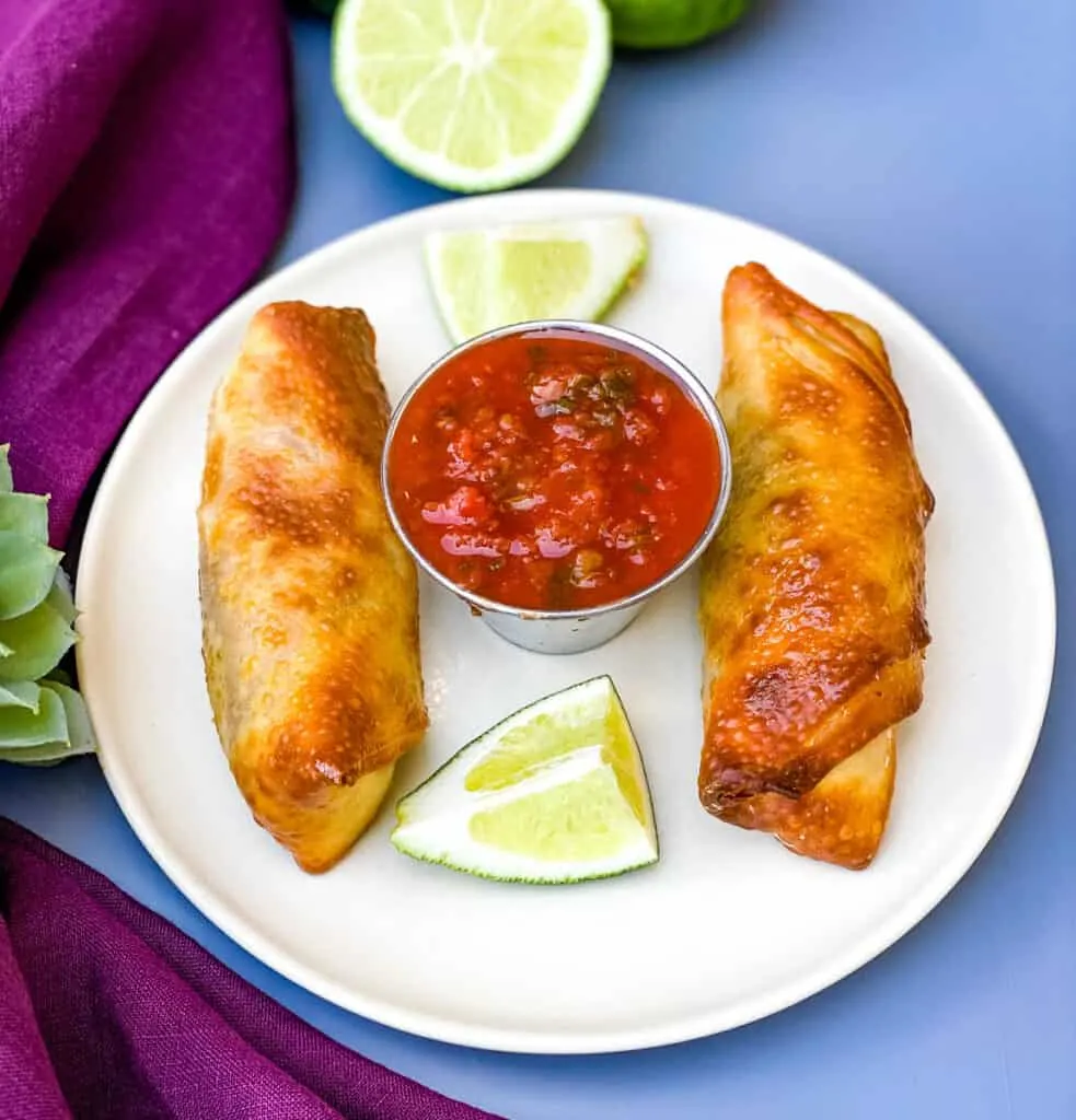 Air Fryer Beef Taco Fried Egg Rolls on a plate with salsa and limes