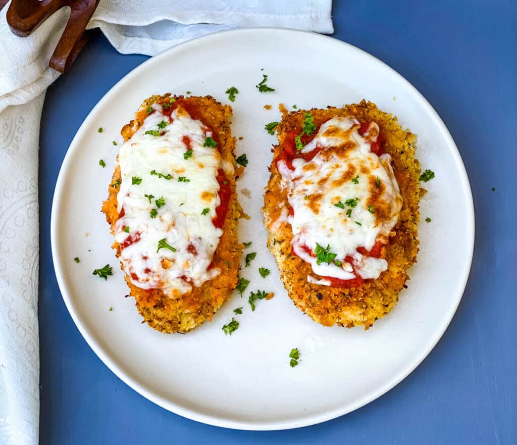 Air Fryer Panko Breaded Chicken Parmesan with Marinara Sauce on a white plate