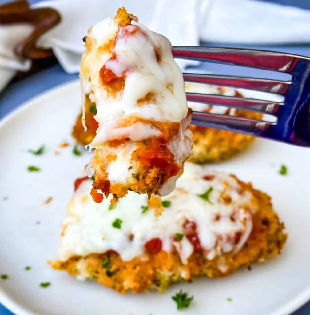 person holding a fork full of air fryer chicken parmesan