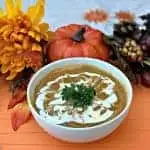 Instant Pot Pumpkin Spice and Sweet Potato Soup in a white bowl with fall decor in the background
