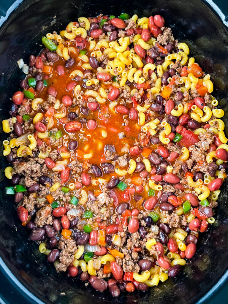 uncooked chili mac and cheese in a slow cooker