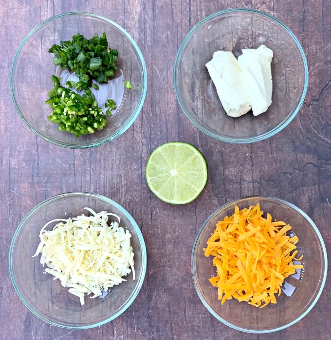 ingredients for keto low carb jalapeno popper chicken including chopped jalapeno, cream cheese, shredded cheese, and fresh lime