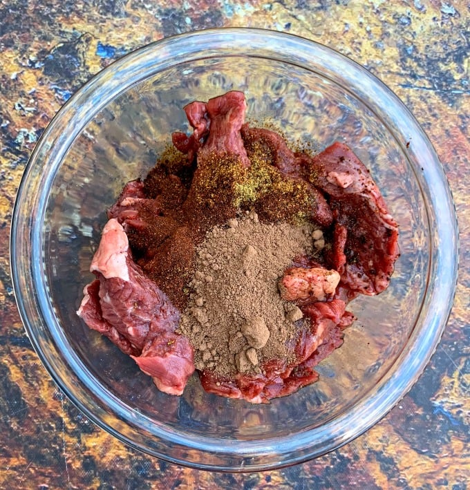 raw steak in a bowl with homemade fajita seasoning