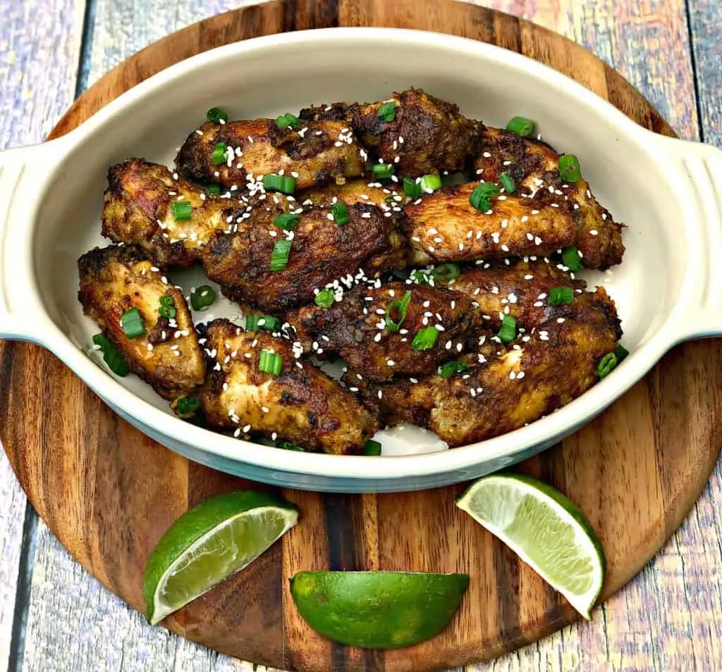 Thai chili chicken wings in a bowl with limes