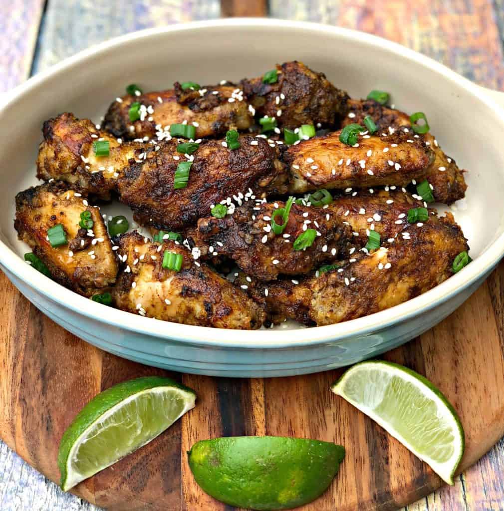 Thai chili chicken wings in a bowl with limes