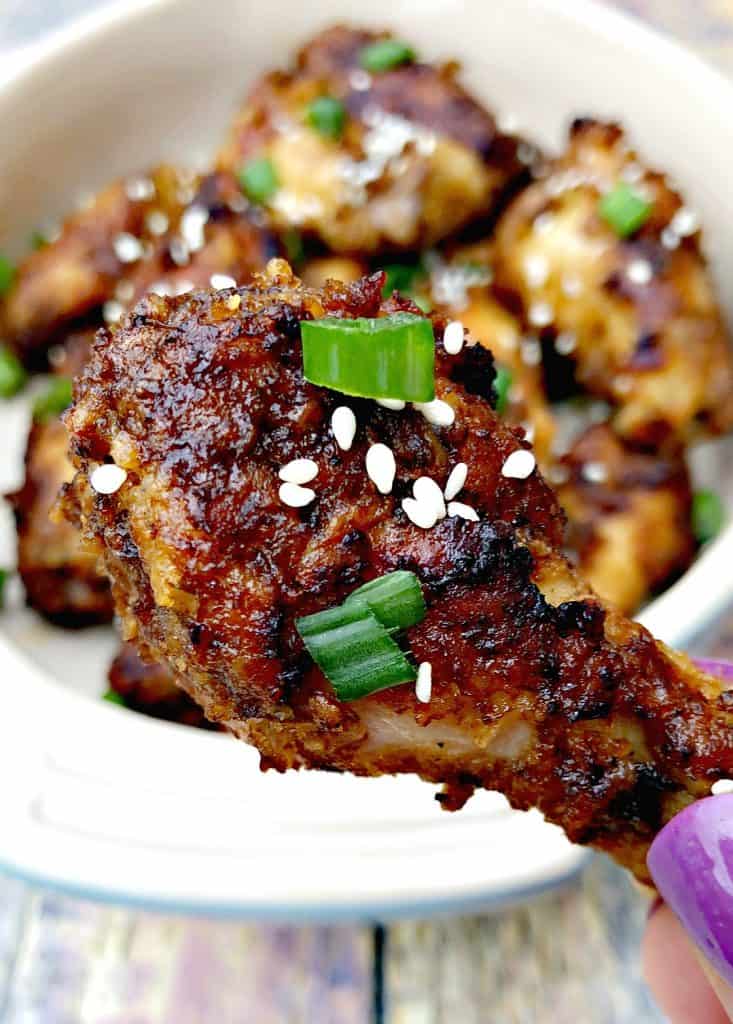 person holding Thai chili chicken wing