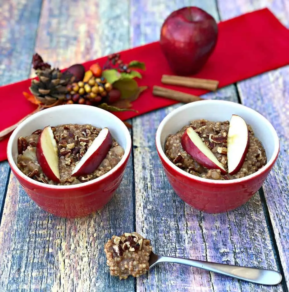 Instant Pot Apple Pie Steel Cut Oats in red bowls with a fresh apple and red napkin