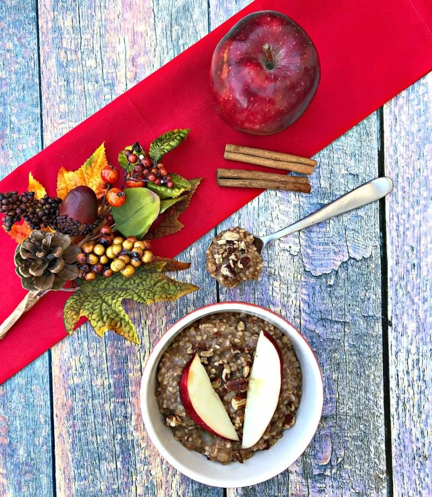 Instant Pot Apple Pie Steel Cut Oats in red bowls with a fresh apple and red napkin