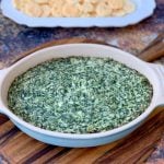 keto low carb spinach dip in a bowl with cheese crisps on a white plate