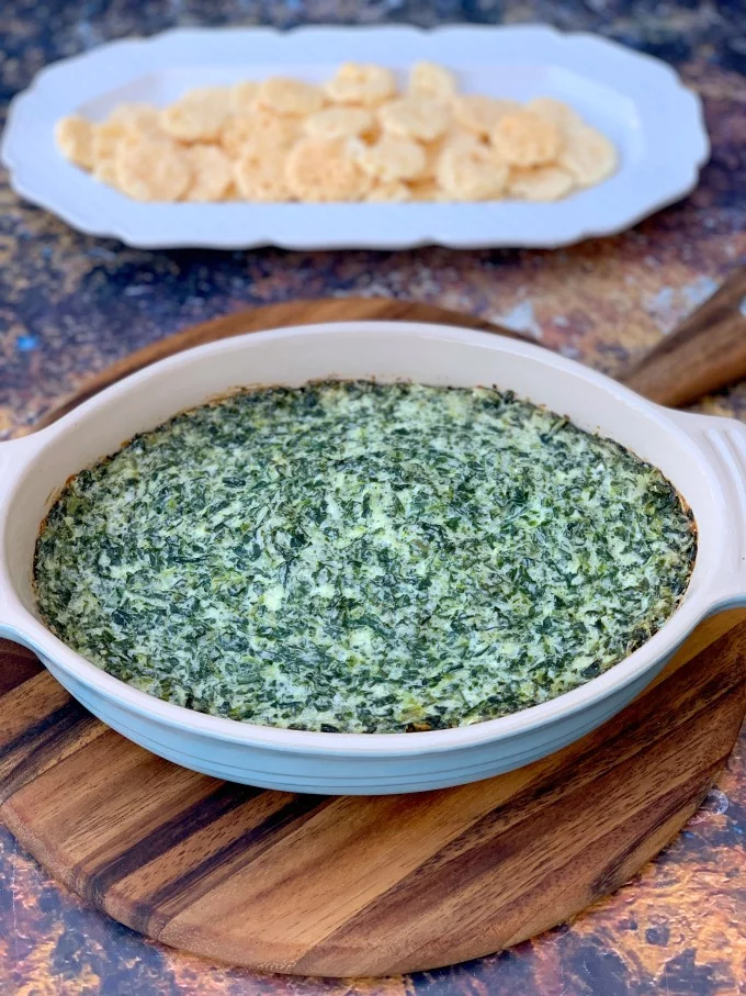 keto low carb spinach dip in a bowl with cheese crisps on a white plate