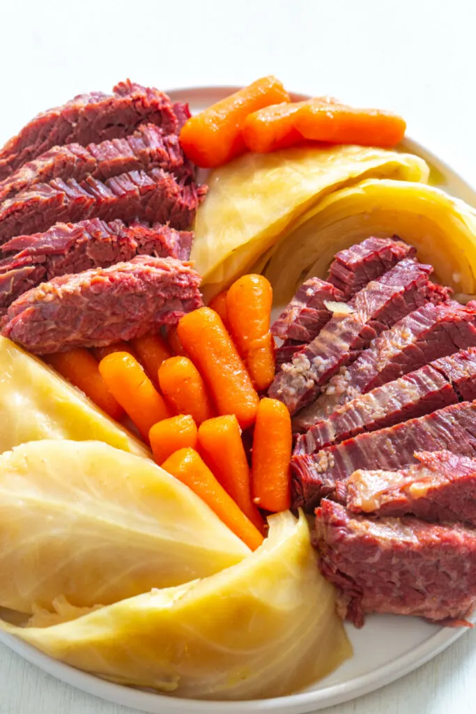 corned beef, carrots, and cabbage on a white plate
