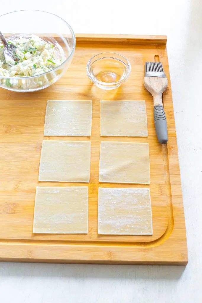 wonton wrappers and crab rangoon filling on a flat surface