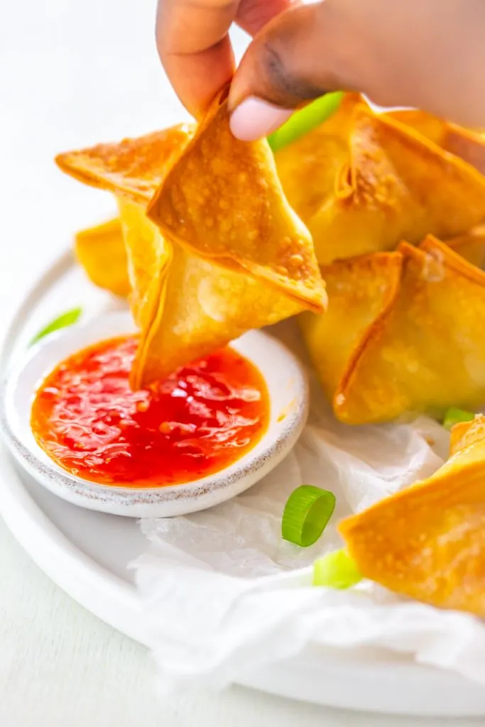 person holding one piece of crab rangoon