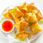 air fryer crab rangoon on a white plate with sauce