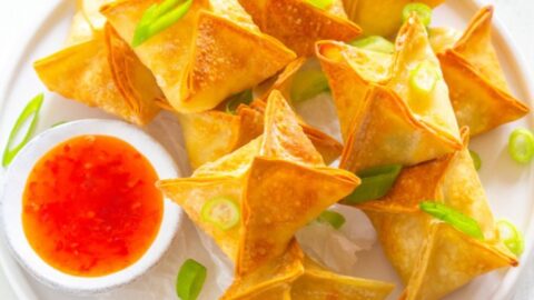 air fryer crab rangoon on a white plate with sauce