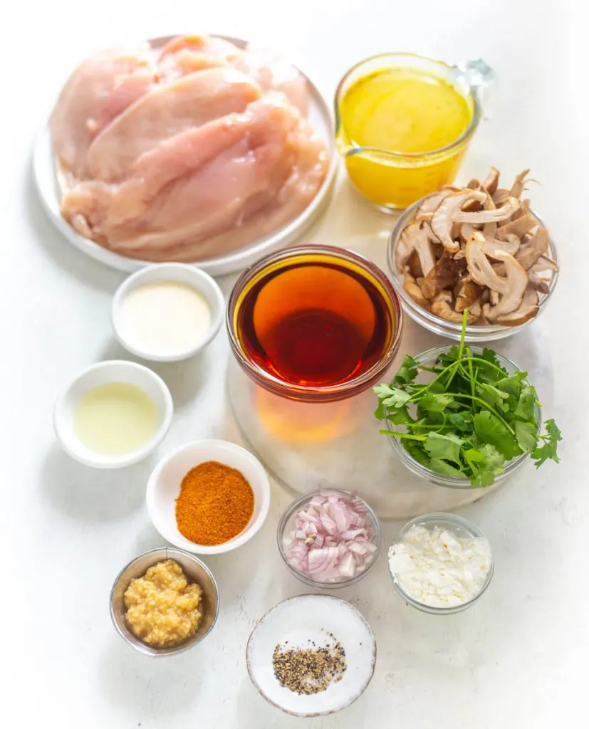 raw chicken breasts, onions, marsala wine, mushrooms, garlic, and seasonings in separate bowls