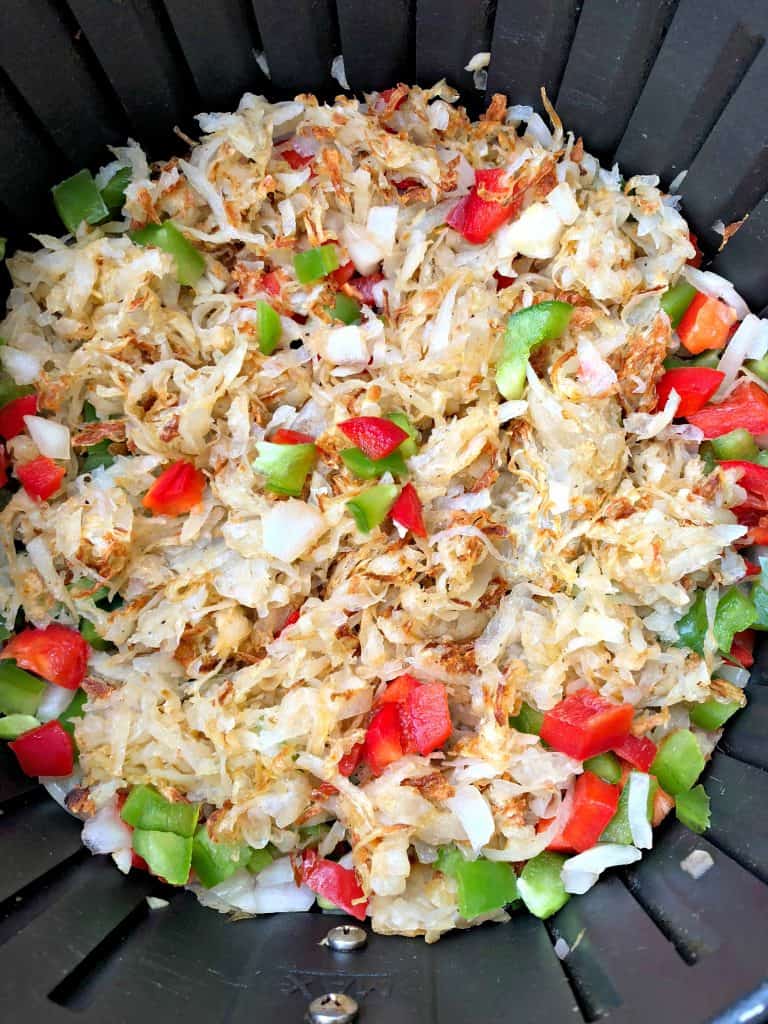 hashbrowns in an air fryer with chopped vegetables