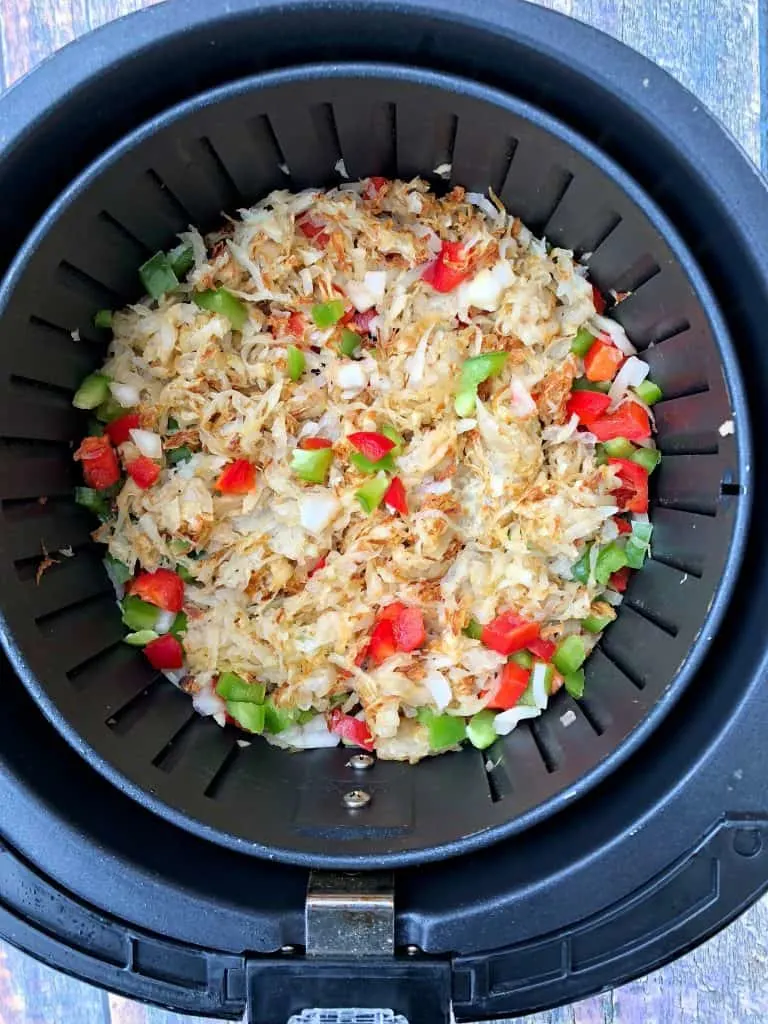 hashbrowns in an air fryer with chopped vegetables