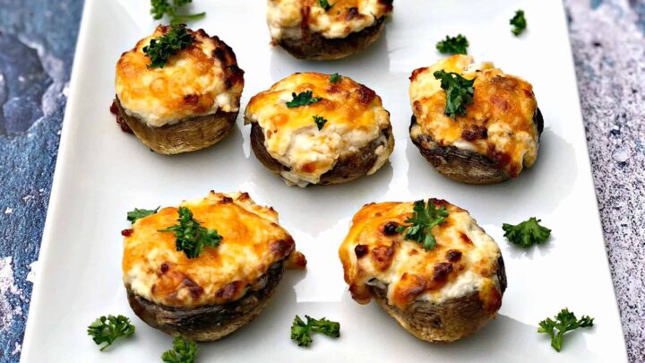 cooked stuffed mushroom with cheese on a white plate